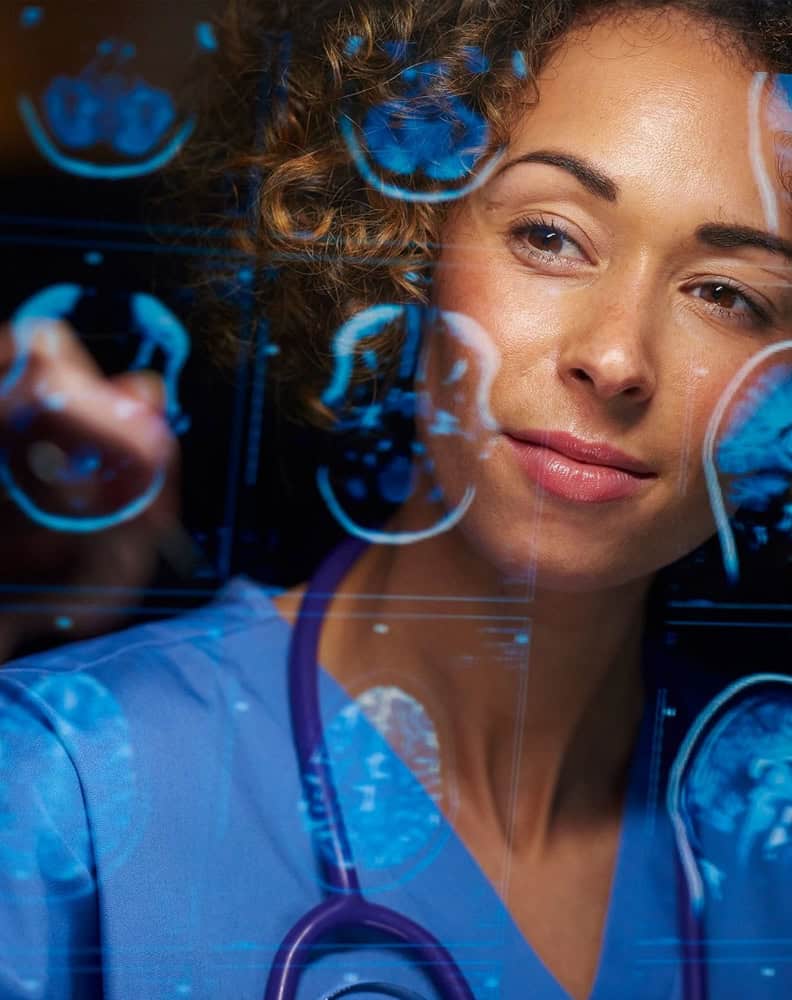 Woman looking at a glass with a reflection of a medical Imaging system shown in a computer screen